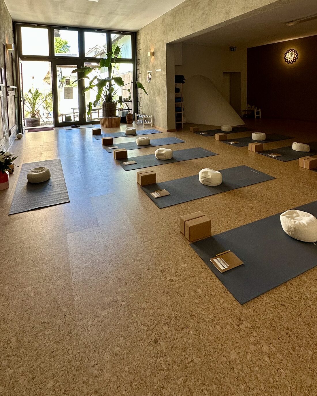 Yoga-Raum mit ausgelegten Matten und Meditationskissen